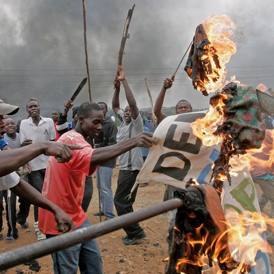 Opposition supporters burn banner