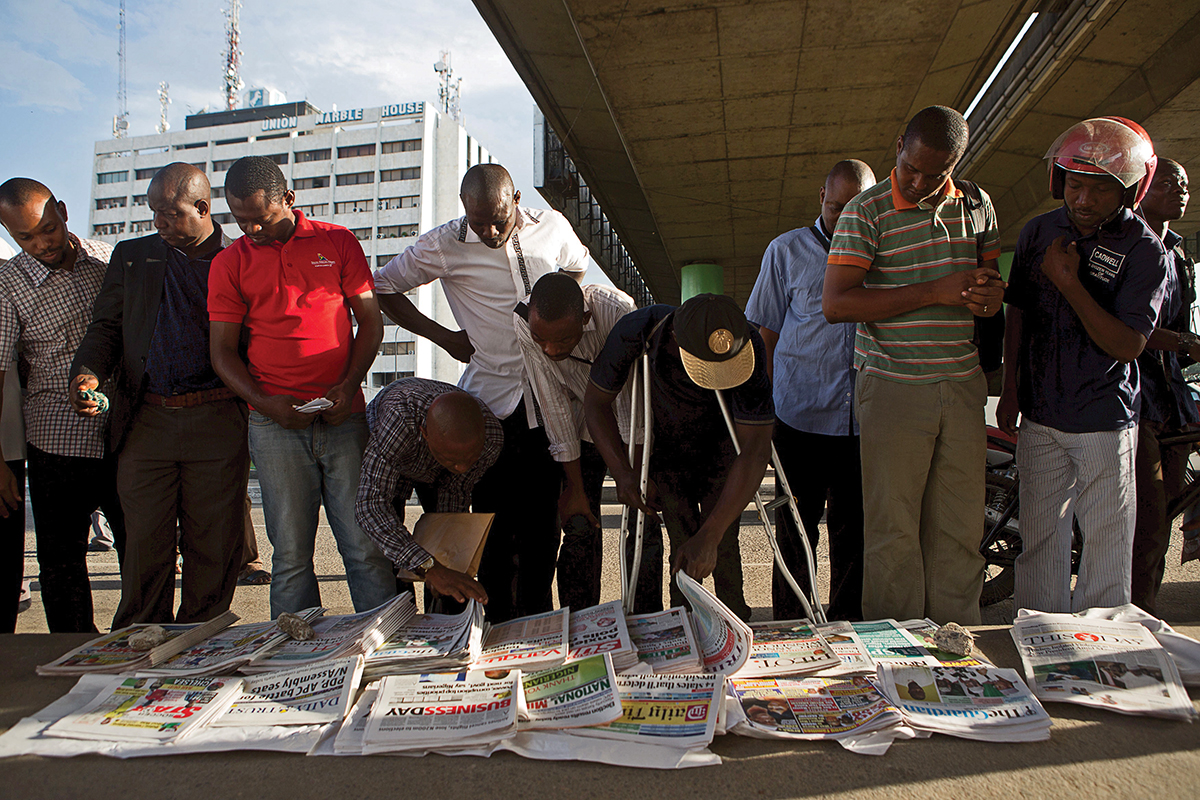 Men reading newspaper headlines